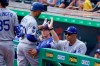 Los Angeles Dodgers' Mookie Betts, center, is greeted at the dugout steps by manager Dave Roberts, right, after hitting a solo home run during the first inning of a baseball game in Pittsburgh, Thursday, June 10, 2021. (AP Photo/Gene J. Puskar)