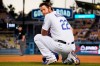 Los Angeles Dodgers' Clayton Kershaw kneels at first as he waits for a pitching change during the third inning of a baseball game against the Texas Rangers Friday, June 11, 2021, in Los Angeles. (AP Photo/Mark J. Terrill)