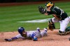 Kansas City Royals' Andrew Benintendi, left, looks for the call after being tagged out at home by Oakland Athletics catcher Aramis Garcia during the eighth inning of a baseball game in Oakland, Calif., Friday, June 11, 2021. (AP Photo/Jeff Chiu)