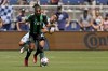 Sporting Kansas City midfielder Roger Espinoza, back, and Austin FC forward Cecilio Dominguez chase the ball during the first half of an MLS soccer match Saturday, June 12, 2021, in Kansas City, Kan. (AP Photo/Charlie Riedel)
