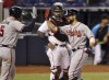 Miami Marlins' catcher Jorge Alfaro looks on as Atlanta Braves' Ender Inciarte, right, is congratulated by teammate Freddie Freeman after hitting a home run during the sixth inning of a baseball game, Sunday, June 13, 2021, in Miami. (AP Photo/Jim Rassol)