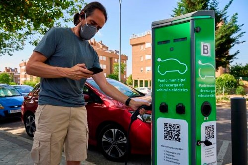 A man charges his electric car at an electrical charging point in Rivas Vaciamadrid, Spain, Tuesday, June 15, 2021. Spain is Europe's second-leading car maker but it is lagging behind when it comes to electric cars, a situation that the government aims to change by using around five billion euros of the EU pandemic recovery funds to kickstart the electric car industry. The government plans to spend big, to install a network of public recharging stations and to convince customers about the benefits of buying electric or hybrid vehicles. (AP Photo/Manu Fernandez)
