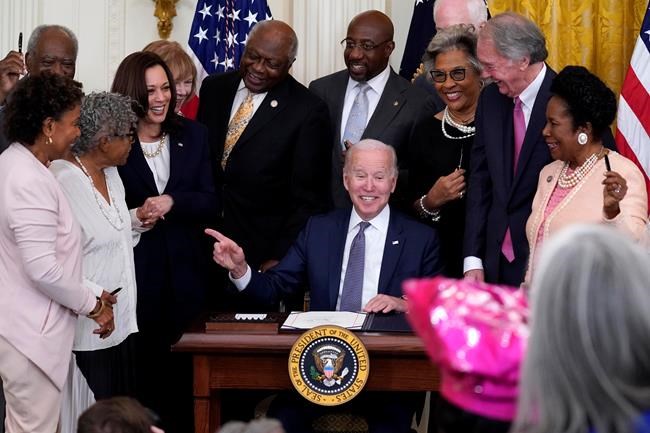 President Joe Biden points to Opal Lee after signing the Juneteenth National Independence Day Act, in the East Room of the White House, Thursday, June 17, 2021, in Washington. From left, Rep. Barbara Lee, D-Calif, Rep. Danny Davis, D-Ill., Opal Lee, Sen. Tina Smith, D-Minn., Vice President Kamala Harris, House Majority Whip James Clyburn of S.C., Sen. Raphael Warnock, D-Ga., Sen. John Cornyn, R-Texas, obscured, Rep. Joyce Beatty, D-Ohio, Sen. Ed Markey, D-Mass., and Rep. Sheila Jackson Lee, D-Texas. (AP Photo/Evan Vucci)