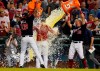 Washington Nationals' Yan Gomes (10), center is doused by teammates Josh Bell (19) and Kyle Schwarber (12) as he is interviewed after hitting a single to drive in the winning run during a baseball game in the ninth inning against the New York Mets, Friday, June 18, 2021, in Washington. (AP Photo/Carolyn Kaster)