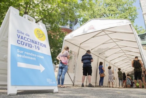 People wait in line to receive a COVID-19 vaccine in Montreal on June 19, 2021. THE CANADIAN PRESS/Graham Hughes