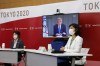 Tokyo 2020 President Seiko Hashimoto, left, Japanese Olympic Minister Tamayo Marukawa, right, and IOC President Thomas Bach, on a screen, attend a five-party online meeting at Harumi Island Triton Square Tower Y in Tokyo Monday, June 21, 2021. The Tokyo Olympics will allow some local fans to attend when the games open in just over a month, Tokyo organizing committee officials and the IOC said on Monday. (Rodrigo Reyes Marin/Pool Photo via AP)