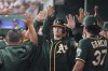 Oakland Athletics catcher Sean Murphy is congratulated by teammates in the dugout after scoring a run in the third inning against the Texas Rangers in a baseball game Tuesday, June 22, 2021, in Arlington, Texas. (AP Photo/Louis DeLuca)