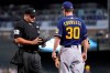 Umpire Jeremy Riggs, left, talks with Milwaukee Brewers manager Craig Counsell, right, after Riggs confiscated the glove from Brewers starting pitcher Freddy Peralta during the first inning of a baseball game against the Arizona Diamondbacks Tuesday, June 22, 2021, in Phoenix. Beginning Monday, Major League Baseball started enforcement of rules that prohibit applying foreign substances to baseballs, as umpires began inspecting gloves, hats and belts of pitchers. (AP Photo/Ross D. Franklin)