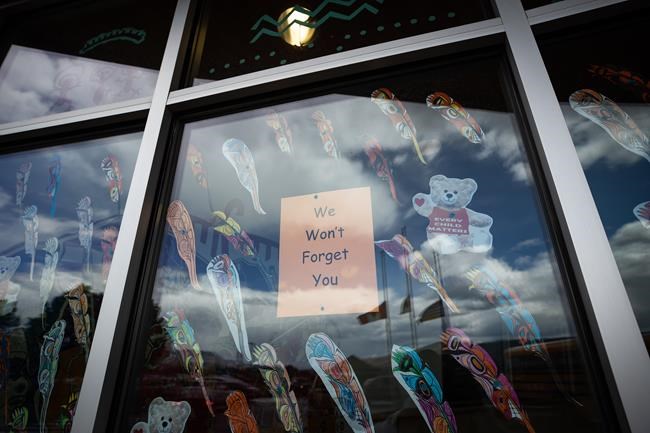 A message is seen on the window of the Sk'elep School of Excellence as the Canadian, Tk'emlups te Secwepemc and B.C. flags are reflected in the window flying at half mast to honour the 215 children whose remains have been discovered buried near the former Kamloops Indian Residential School, in Kamloops, B.C., on Saturday, June 5, 2021. A First Nation in southern Saskatchewan is to hold a virtual news conference Thursday morning about what it calls
