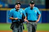 Home plate umpire Tom Hallion, left, makes Tampa Bay Rays relief pitcher Diego Castillo change his hat during the ninth inning of a baseball game Wednesday, June 23, 2021, in St. Petersburg, Fla. Looking on is first base umpire Mark Ripperger. (AP Photo/Chris O'Meara)