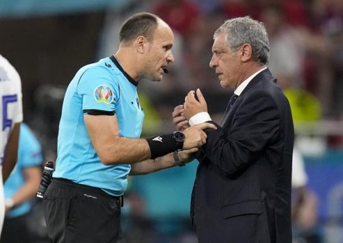 Referee Antonio Mateu Lohoz, left, talks with Portugal's manager Fernando Santos during the Euro 2020 soccer championship group F match between Portugal and France at the Puskas Arena, Budapest, Hungary, Wednesday, June 23, 2021. (AP Photo/Darko Bandic,Pool)