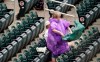 A fan shakes out a rain cover as she prepares fold up it up before leaving the ballpark as the Minnesota Twins baseball game against the Cleveland Indians was postponed, Saturday, June 26, 2021, in Minneapolis, due to heavy rain forecast in the area for much of the day. (AP Photo/Jim Mone)