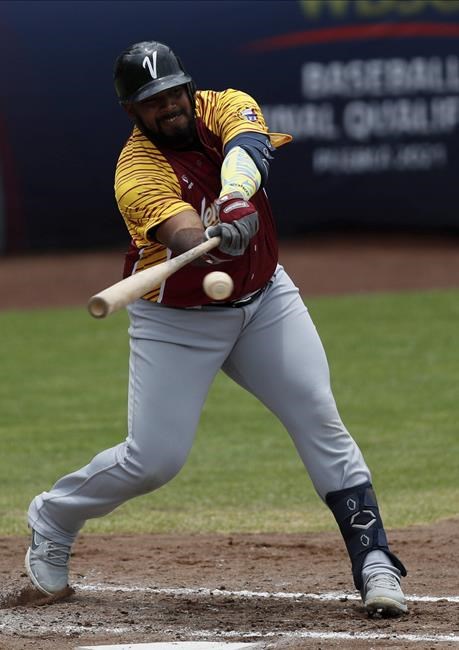 Venezuela outfielder Alexander Palma hits a single against the Dominican Republic during a final Olympic baseball qualifier game, in Puebla, Mexico, Saturday, June 26, 2021. (AP Photo/Fernando Llano)