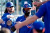 Chicago Cubs' Jason Heyward gets congratulations from teammates after scoring on a Ian Happ RBI double against the Los Angeles Dodgers during the fifth inning of a baseball game in Los Angeles, Saturday, June 26, 2021. (AP Photo/Alex Gallardo)