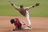 San Diego Padres second baseman Jake Cronenworth, top, leaps over Arizona Diamondbacks' Josh Rojas who arrives safely to second base on a fielder's choice hit into by Eduardo Escobar and a throwing error by Padres shortstop Fernando Tatis Jr. during the seventh inning of a baseball game Sunday, June 27, 2021, in San Diego. Two runs scored on the play. (AP Photo/Gregory Bull)