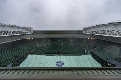 Covers remain in place on the Centre Court as rain continues to fall in the early morning ahead of the first day's play at Wimbledon Tennis Championships in London Monday June 28, 2021. (Joe Toth/Pool via AP)