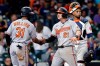 Baltimore Orioles' Cedric Mullins (31) and Austin Hays (21) celebrate in front of Houston Astros catcher Martin Maldonado, right, after they both scored on the home run by Hays during the ninth inning of a baseball game Monday, June 28, 2021, in Houston. (AP Photo/Michael Wyke)