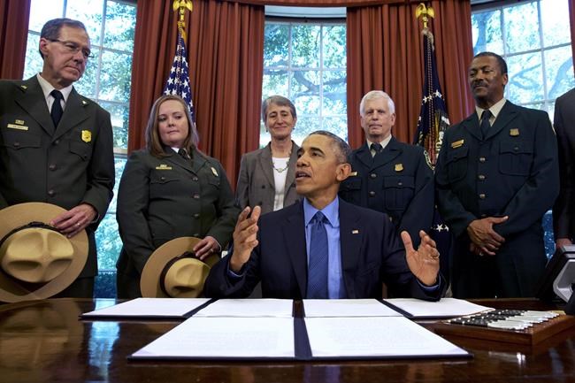 FILE - In this July 10, 2015, file photo, President Barack Obama, center, talks about the designation of three new national monuments in the Oval Office of the White House in Washington. Behind him from left are Victor Knox, associate director of park planning, facilities and lands of the National Park Service; April Slayton, chief of public affairs and chief spokesperson of the National Park Service; Secretary of the Interior Sally Jewell; U.S. Forest Service Chief Tom Tidwell; and Randy Moore, Forest Service. Veteran forester Randy Moore has been named chief of the U.S. Forest Service, the first African American to lead the agency in its 116-year history. (AP Photo/Jacquelyn Martin, File)