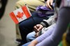 A young new Canadian holds a flag as she takes part in a citizenship ceremony on Parliament Hill in Ottawa on April 17, 2019. It will be a muted Canada Day in many parts of the country as grief and anger over the discovery of hundreds of unmarked graves at former residential schools has made it hard for many Canadians to stomach the usual patriotic pomp of July 1. Rather than fireworks, parades and performances, several municipalities say they will mark the national holiday with reflection and solidarity, but Indigenous leaders, advocates and scholars say that's just the start of broad efforts needed to reframe Canada Day as a reminder of the country's dark past and present, and what it means to be Canadian. THE CANADIAN PRESS/Sean Kilpatrick