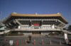 FILE - In this Thursday, Jan. 21, 2021, file photo, a man and a woman walk past the Nippon Budokan arena in Tokyo. Judo is coming home at the Tokyo Olympics, and the Japanese team is under a world of pressure. As if this eight-day tournament wasn’t already significant enough, the players will compete at the Nippon Budokan, the hallowed arena built for the first Olympic judo events. (AP Photo/Hiro Komae, File)