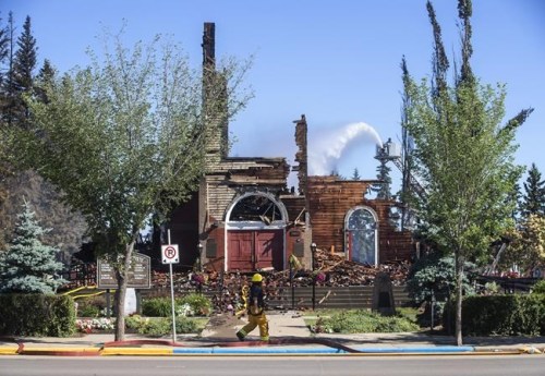 St. John Baptiste Parish Catholic church is shown in Morinville Alta, on Wednesday, June 30, 2021 as firefighters put out hot spots. RCMP are calling the fire suspicious. THE CANADIAN PRESS/Jason Franson