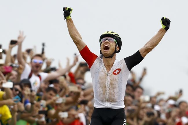 FILE - Nino Schurter of Switzerland celebrates after winning the men's cross-country cycling mountain bike race at the 2016 Summer Olympics in Rio de Janeiro, Brazil, in this Saturday, Aug. 20, 2016, file photo. Defending champion Nino Schurter of Switzerland will go for his fourth consecutive Olympic medal at the Tokyo Games. (AP Photo/Patrick Semansky, File)