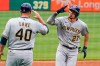Milwaukee Brewers' Willy Adames (27) rounds third to greetings from coach Jason Lane (40) after hitting a solo home run off Pittsburgh Pirates starting pitcher JT Brubaker during the first inning of a baseball game in Pittsburgh, Friday, July 2, 2021. (AP Photo/Gene J. Puskar)