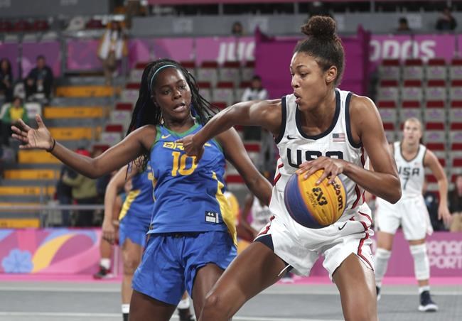 FILE - In this July 29, 2019, file photo, Olivia Nelson, right, of the United States, drives around Evelyn Mariano, of Brazil, during the women's basketball 3x3 semifinal match at the Pan American Games in Lima, Peru. The Olympics website calls 3x3 basketball “exciting, urban and innovative.” It was added to the program for Tokyo to lure a younger audience and get more countries involved in one of the core sports of the Olympic Games. (AP Photo/Martin Mejia, File)