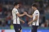 England's Harry Maguire, left, congratulates England's John Stones at the end of the Euro 2020 soccer championship quarterfinal soccer match between Ukraine and England at the Olympic stadium, in Rome, Italy, Saturday, July 3, 2021. England won 4-0. (Lars Baron/Pool Photo via AP)