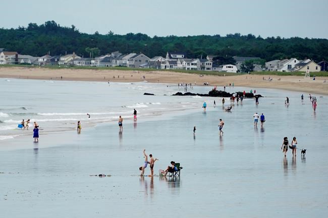 Without the annual influx of Canadian tourists, beach-goers have plenty of room to spread out, Thursday, July 1, 2021, in Old Orchard Beach, Maine. From the Atlantic to the Pacific, people along the U.S.-Canadian border are hoping the border will open again soon so people can travel in both directions. (AP Photo/Robert F. Bukaty)