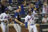 Milwaukee Brewers starting pitcher Brandon Woodruff, center, reacts as New York Mets' Francisco Lindor and Dominic Smith, left, celebrate after scoring on a double by Pete Alonso during the seventh inning of a baseball game, Monday, July 5, 2021, in New York. (AP Photo/Frank Franklin II)