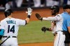 Miami Marlins' Starling Marte, second from right, is congratulated by Adam Duvall (14) after scoring on a single by Garrett Cooper during the third inning of a baseball game against the Los Angeles Dodgers, Monday, July 5, 2021, in Miami. (AP Photo/Wilfredo Lee)