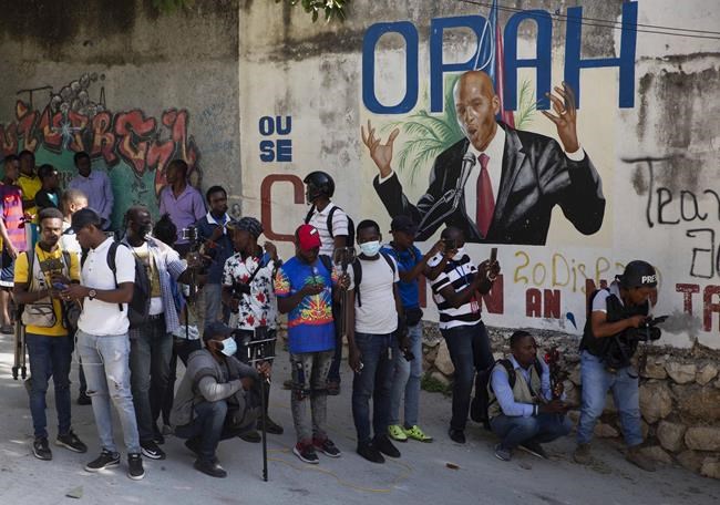 Journalists gather near a mural featuring Haitian President Jovenel Moise, near the leader’s residence where he was killed by gunmen in the early morning hours, and his wife was wounded, in Port-au-Prince, Haiti, Wednesday, July 7, 2021. Claude Joseph, the interim prime minister, confirmed the killing and said the police and military were in control of security in Haiti. (AP Photo/Joseph Odelyn)