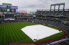 The tarp covers the infield at Citi Field, where the scheduled baseball game between the New York Mets and the Milwaukee Brewers has been postponed, Thursday, July 8, 2021, in New York. The game was rescheduled for Saturday as part of a doubleheader. (AP Photo/Frank Franklin II)