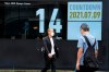 People wearing face masks walk past the countdown clock for the Tokyo 2020 Olympic Games near Shimbashi station Friday, July 9, 2021, in Tokyo. (AP Photo/Eugene Hoshiko)
