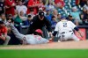 Cincinnati Reds' Aristides Aquino (44) is tagged out at third base by Milwaukee Brewers' Luis Urias (2) during the fourth inning of a baseball game Friday, July 9, 2021, in Milwaukee. (AP Photo/Aaron Gash)