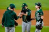Oakland Athletics manager Bob Melvin, left, takes the ball from starting pitcher Cole Irvin, center, during the sixth inning of the team's baseball game against the Texas Rangers, as catcher Sean Murphy, right, looks on in Arlington, Texas, Friday, July 9, 2021. (AP Photo/Tony Gutierrez)