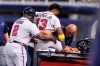 Atlanta Braves right fielder Ronald Acuna Jr., center, is helped onto a medical cart after trying to make a catch on an inside-the-park home run hit by Miami Marlins' Jazz Chisholm Jr. during the fifth inning of a baseball game, Saturday, July 10, 2021, in Miami. (AP Photo/Lynne Sladky)