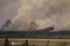 Fire crews drop fire retardant from the air near a forest fire burning northeast of the city of Prince Albert, Sask., on Monday, May 17, 2021. THE CANADIAN PRESS/Kayle Neis
