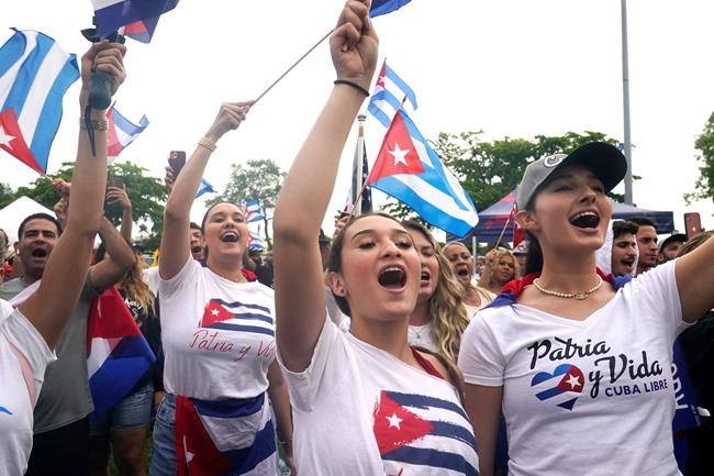 Demonstrators sing the Cuban national anthem during a rally, Tuesday, July 13, 2021, in Miami. Several protests broke out in Miami in solidarity with the thousands of Cubans who waged a rare weekend of protests around their island nation against the communist regime. (AP Photo/Marta Lavandier)