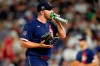 American League's Liam Hendriks, of the Chicago White Sox, right, takes a hit of oxygen on the mound during the ninth inning of the MLB All-Star baseball game, Tuesday, July 13, 2021, in Denver. (AP Photo/Jack Dempsey)
