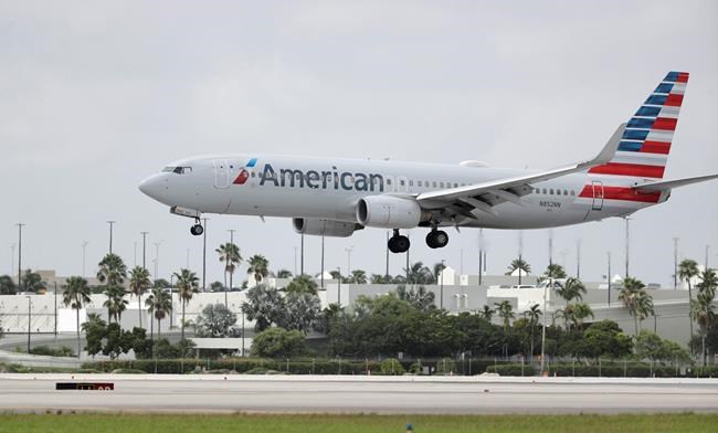 FILE - In this Monday, July 27, 2020, file photo, An American Airlines Boeing 737-823 lands at Miami International Airport in Miami. American Airlines is telling some flight attendants to cut short their leaves of absence and come back to work. The airline said Thursday, July 15, 2021 that it is canceling extended leaves for about 3,300 flight attendants, and it wants them flying by November or December. Plus, the airline expects to hire 800 new flight attendants by next March. (AP Photo/Wilfredo Lee, File)