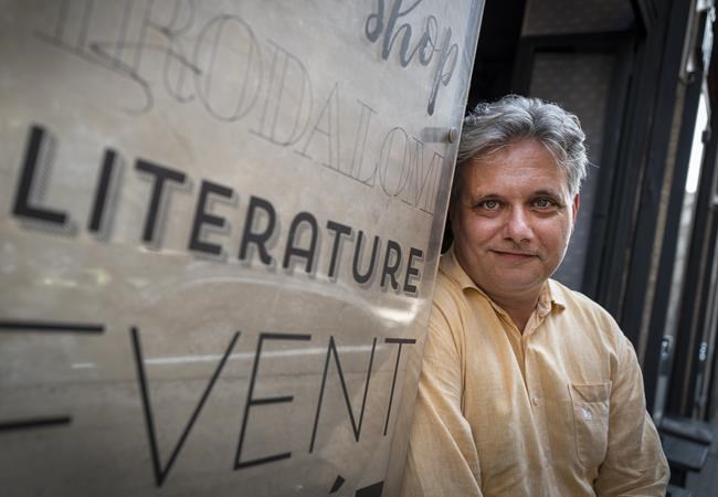 Publisher of Lira Konyv, Krisztian Nyaryposes for a photo in Budapest, Tuesday, July 13, 2021. A recent Hungarian law that prohibits “depicting or promoting” homosexuality or sex reassignment to minors has some bookstores in Hungary placing notices at their entrances, warning customers over books containing “non-traditional content.” Some writers and publishers say the controversial law narrows free thought and expression in literature - and are uncertain over whether works that depict homosexual themes will require labeling to keep them from reaching minors under 18. (AP Photo/Bela Szandelszky)