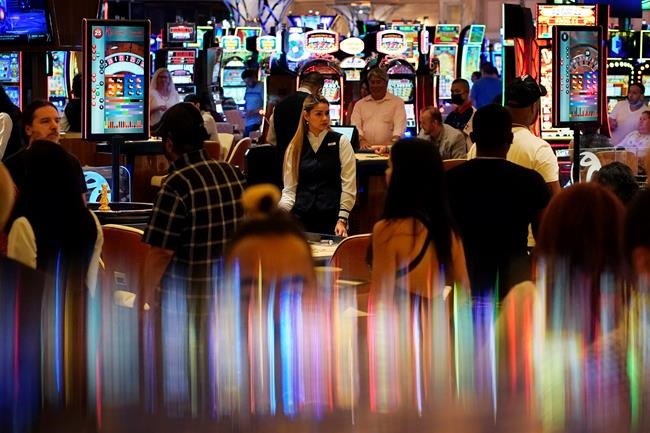 FILE - In this June 24, 2021, file photo, crowds walk through the casino during the opening night of Resorts World Las Vegas in Las Vegas. Masks are back in Las Vegas, where regional health officials pointed Friday, July 16, 2021, to a rising number of coronavirus cases and advised everyone, vaccinated or not, to wear facial coverings in crowded indoor places. Seven weeks ago, Nevada fully lifted coronavirus restrictions and returned pandemic control measures to counties. (AP Photo/John Locher, File)
