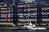 National banners hang from balconies at an athlete's village as Tokyo prepares for the 2020 Summer Olympics, Sunday, July 18, 2021. The pandemic-delayed games open on July 23 without spectators at most venues. (AP Photo/Charlie Riedel)