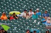 Baseball Fans sit in the rain as they watch a baseball game between the Atlanta Braves and the Tampa Bay Ray,s Sunday, July 18, 2021, in Atlanta. (AP Photo/John Bazemore)