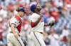 Philadelphia Phillies closing pitcher Hector Neris, right, gestures as he walks with catcher J.T. Realmuto after the Phillies defeated the Miami Marlins in a baseball game, Sunday, July 18, 2021, in Philadelphia. (AP Photo/Laurence Kesterson)