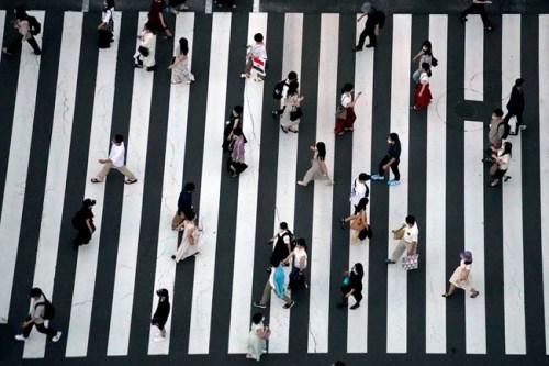 People wearing protective masks to help curb the spread of the coronavirus walk along a pedestrian crossing Thursday, July 22, 2021, in Tokyo. The Japanese capital confirmed more than 1900 new coronavirus cases on Thursday. (AP Photo/Eugene Hoshiko)