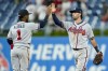 Atlanta Braves' Dansby Swanson, right, gives Ozzie Albies, left a high-five following the ninth inning of a baseball game against the Philadelphia Phillies, Thursday, July 22, 2021, in Philadelphia. (AP Photo/Chris Szagola)
