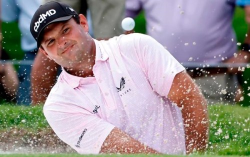 FILE - In this May 27, 2021, file photo, Patrick Reed plays a shot from a bunker on the fifth hole during the first round of the Charles Schwab Challenge golf tournament at the Colonial Country Club in Fort Worth, Texas. Bryson DeChambeau has tested positive for COVID-19 before leaving the United States for the Olympics and will miss the Tokyo Games. He’ll be replaced by Reed. (AP Photo/Ron Jenkins, File)